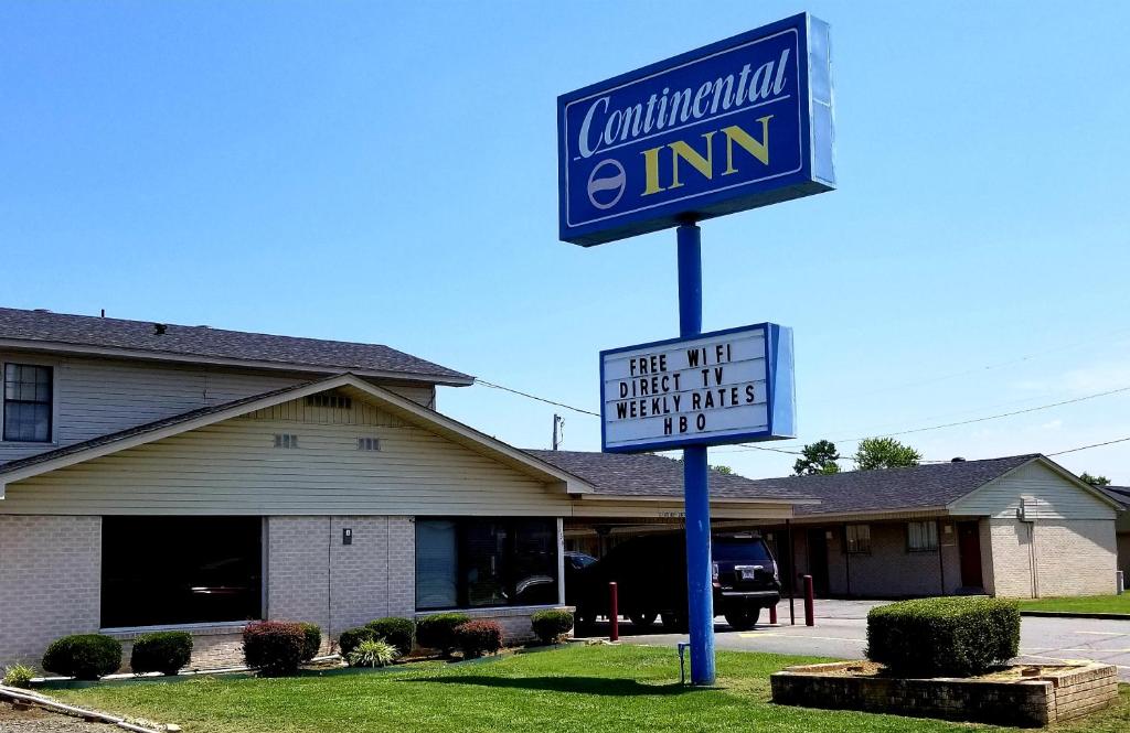 Continental Inn in Conway, Arkansas. The large blue sign with white and yellow lettering stands in front of the one-story motel and a letterboard says "Free Wifi Direct TV Weekly Rates HBO."