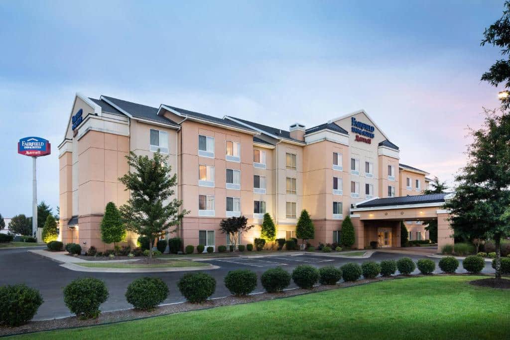 Fairfield Inn & Suites in Conway Arkansas. The hotel is a peachy color with four stories and a narrow parking lot.