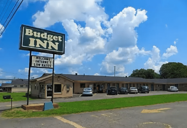 Budget Inn in Conway Arkansas. The sign is blue with white letters and below it is a letterboard sign that says "Welcome Internet Low Rates." The building is one story with a gray roof.